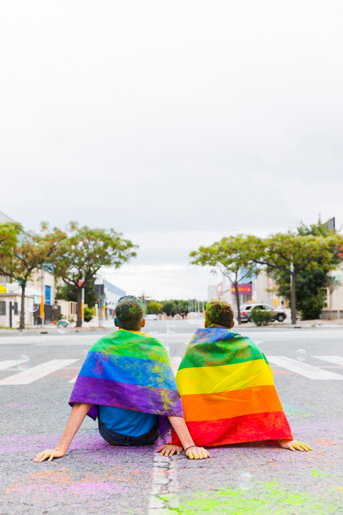 Una pareja gay muestra y porta con orgullo la bandera gay