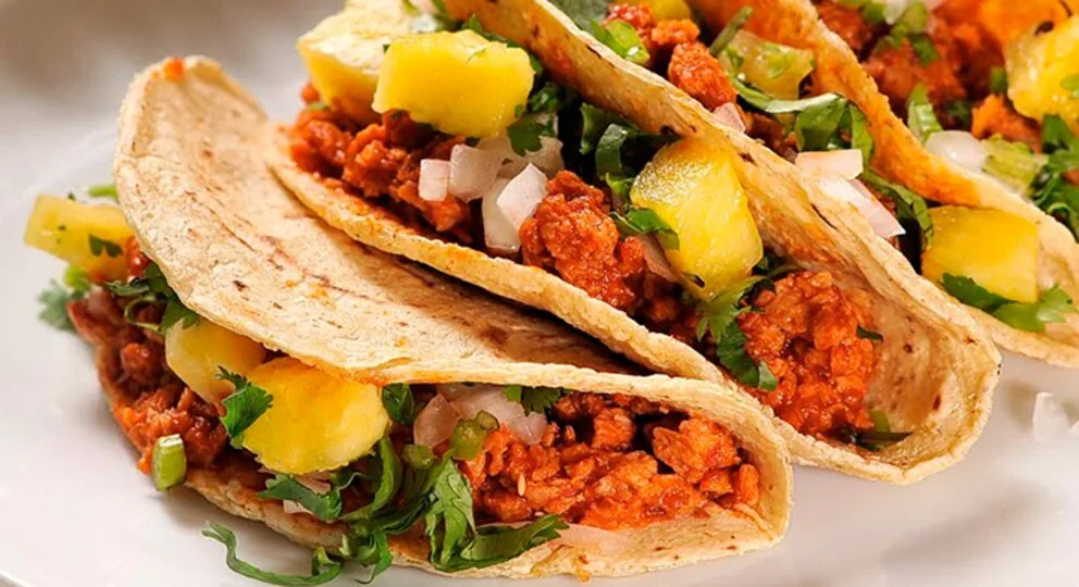 El origen de los tacos al pastor es una historia de migración, fusión cultural y creatividad mexicana. Este platillo se convirtió en uno de los grandes símbolos de la gastronomía mexicana. Descubre cómo nació, por qué se sirve en trompo y cómo conquistó al mundo.