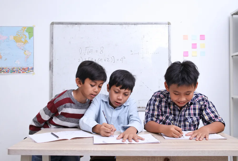 Niños estudiando en salón de clases.