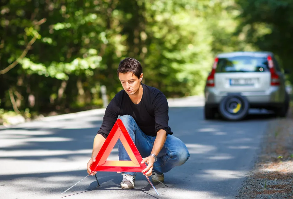 Triángulos de seguridad en carretera por auto descompuesto