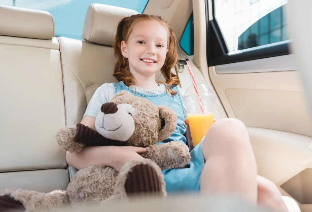 El "Kit de Supervivencia" emocional: La psicología del viaje feliz. Niña viaja cno oso de peluche.